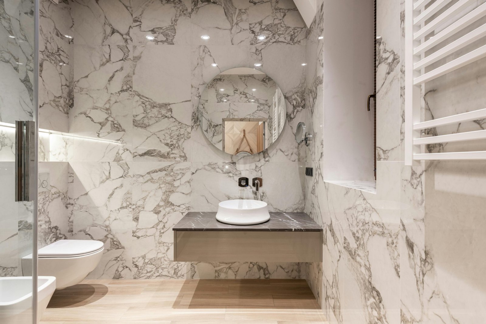 Contemporary restroom with marble walls and parquet floor