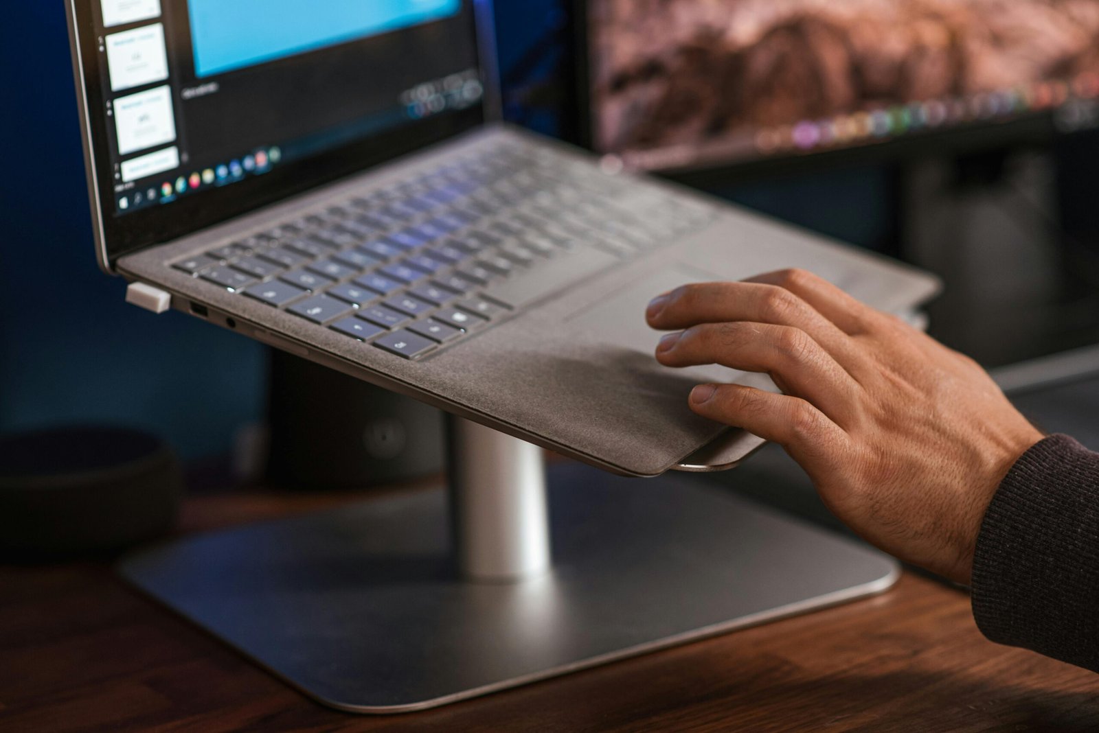 Crop faceless man using laptop on stand