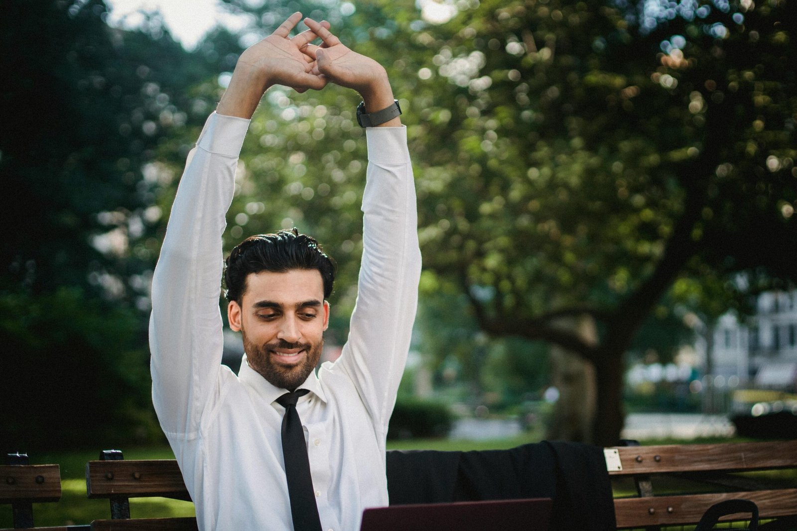 Man in White Dress Shirt and Black Necktie Stretching Arms